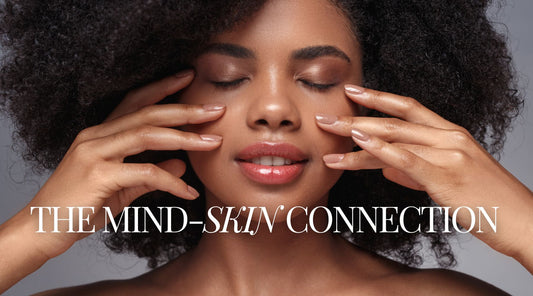 Woman with glowing skin touching her face, representing the connection between stress, cortisol, and skin health.