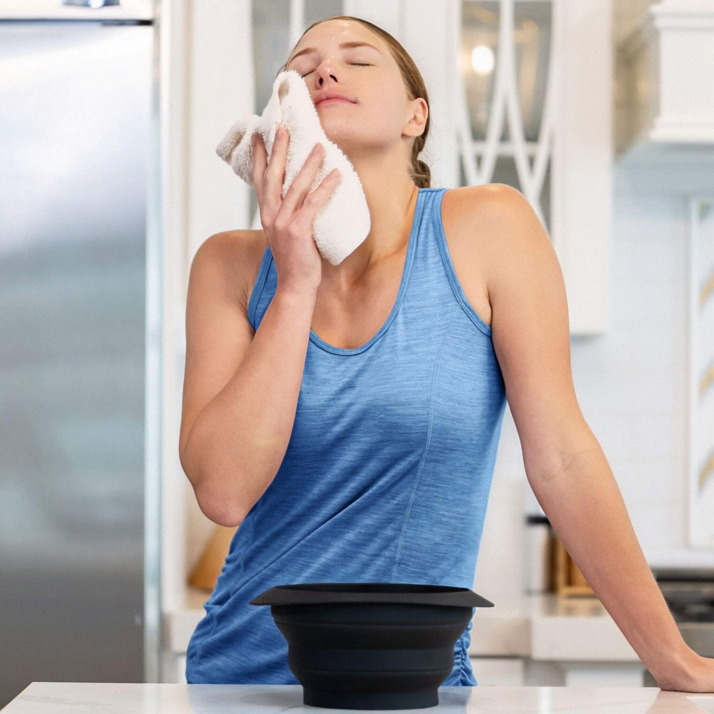 Woman enjoying post-treatment cooling effect from using cold face plunge bowl for ice therapy.