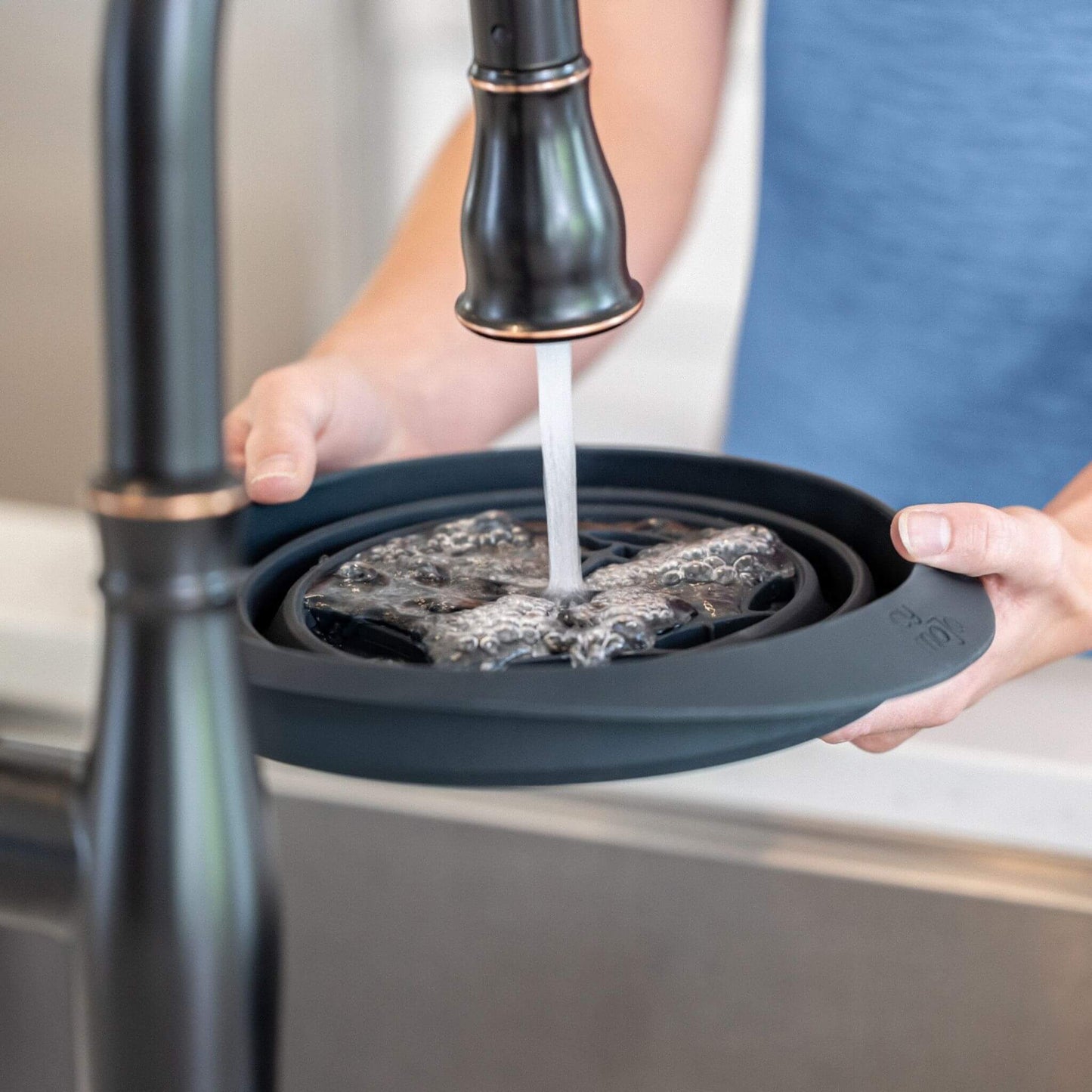 Filling the built-in ice tray of the face plunge bowl with water for freezing step.